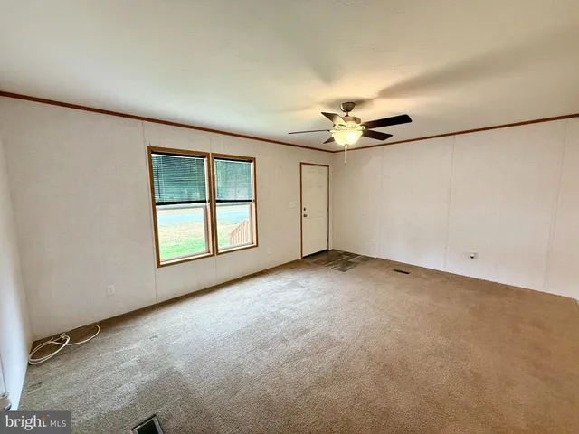 an empty room with a ceiling fan and a window