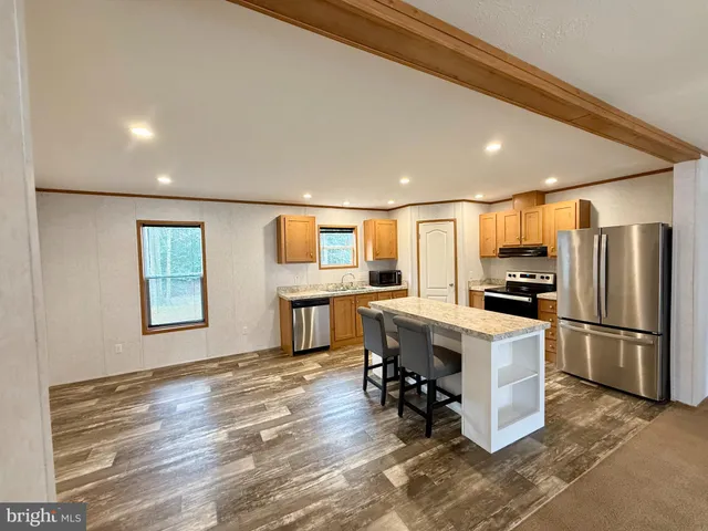 a kitchen with stainless steel appliances a refrigerator and a stove top oven