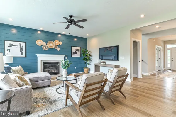 a living room with furniture a fireplace and a large window