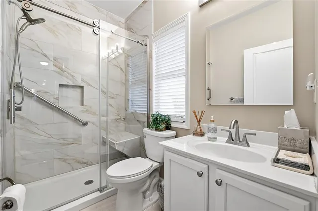 a bathroom with a sink a toilet and shower