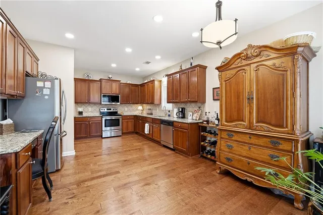 a kitchen with stainless steel appliances granite countertop a refrigerator and a sink