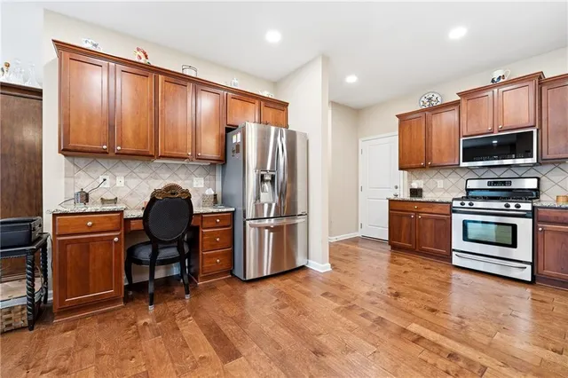 a kitchen with granite countertop a refrigerator stove and microwave