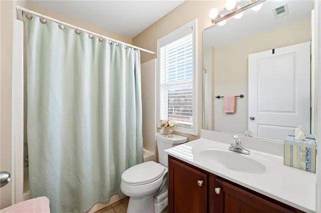 a bathroom with a double vanity sink toilet and a mirror