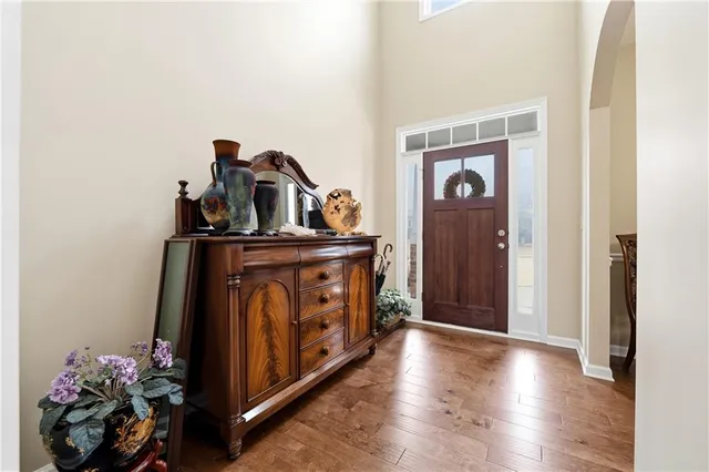 a view of a hallway with entryway wooden floor and a front door