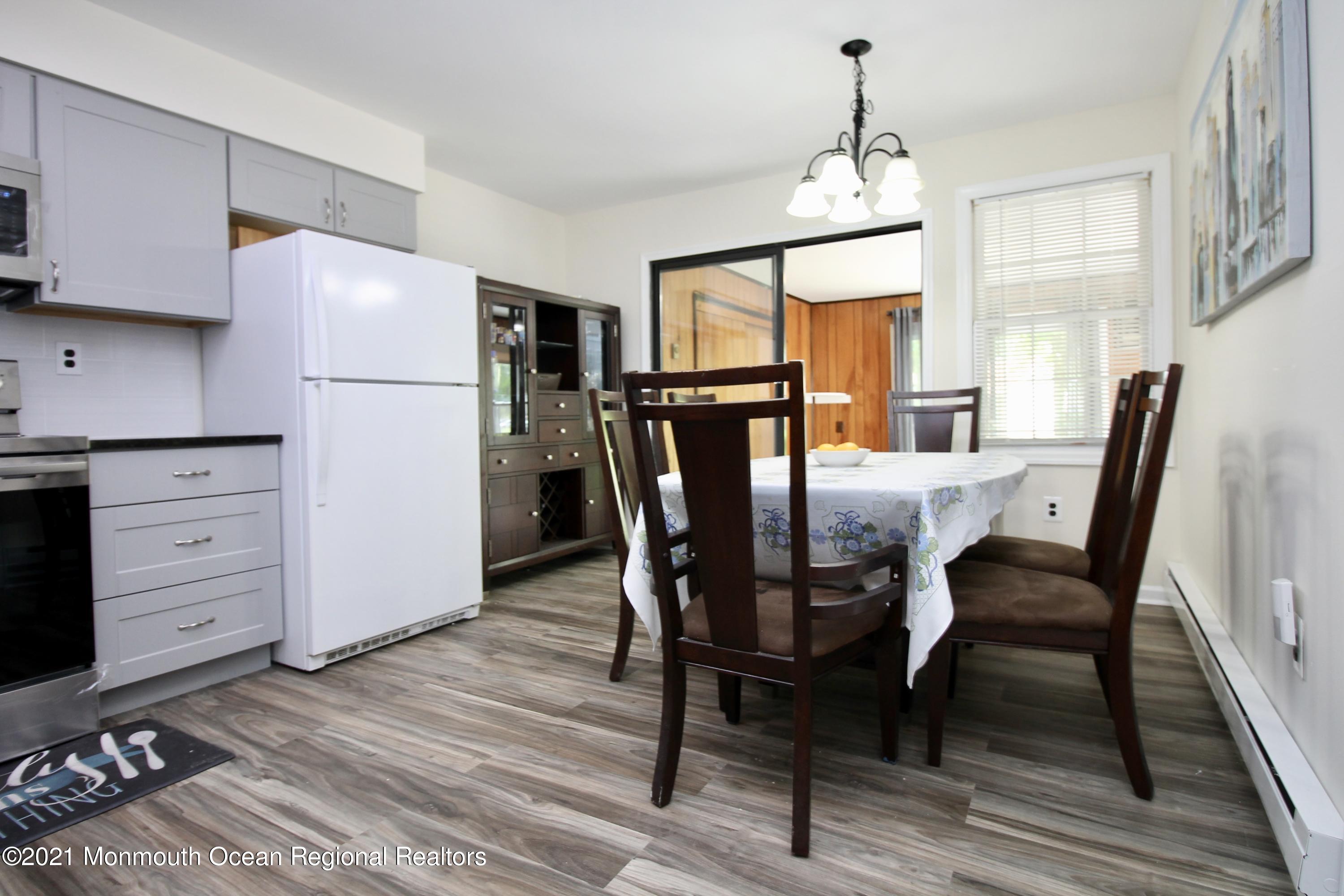 152 Cours De Pasteur, Unit E Freehold, NJ 07728 - Photo 12 of 21 a view of a dining room with furniture window and wooden floor