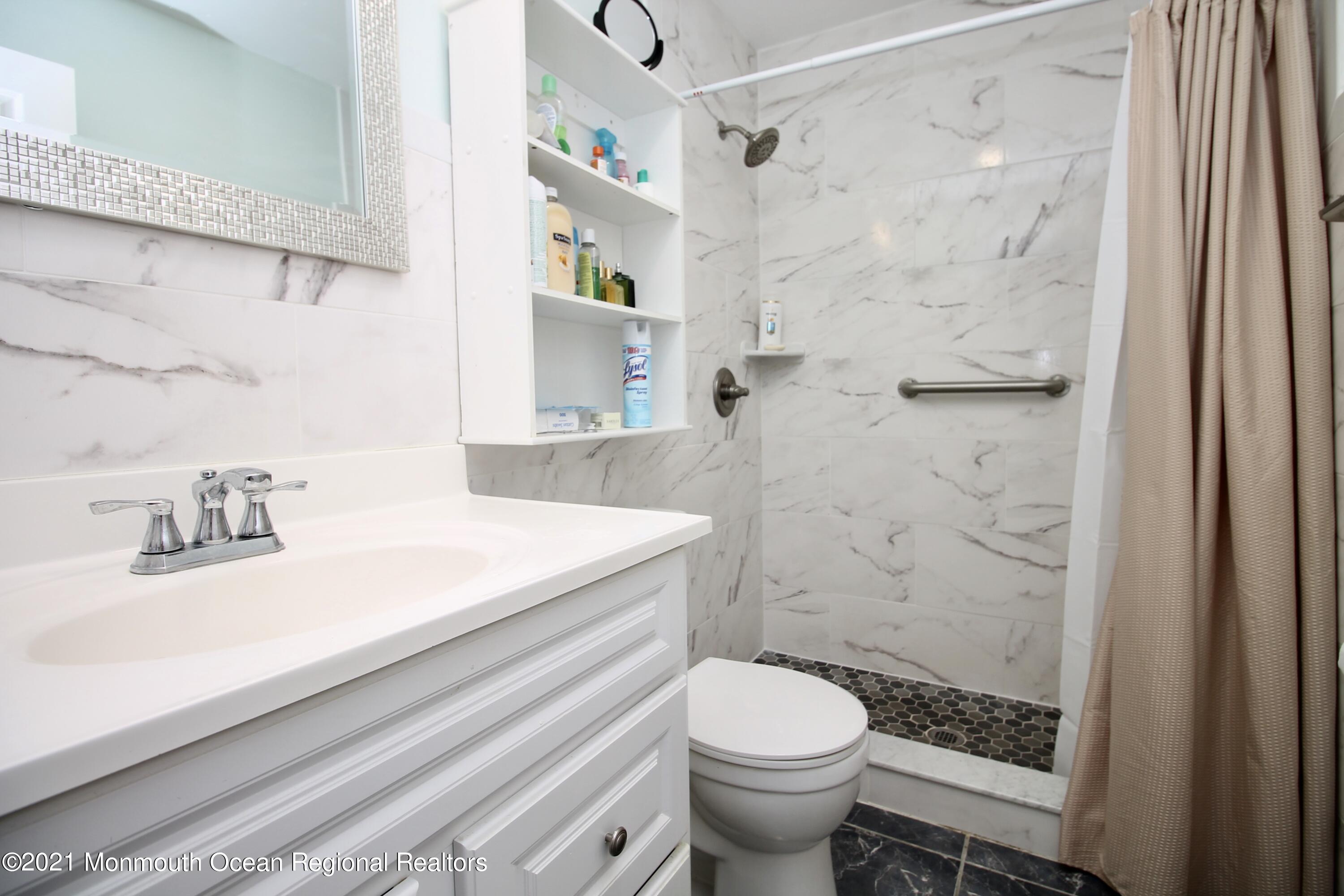 152 Cours De Pasteur, Unit E Freehold, NJ 07728 - Photo 14 of 21 a bathroom with a sink a toilet and shower