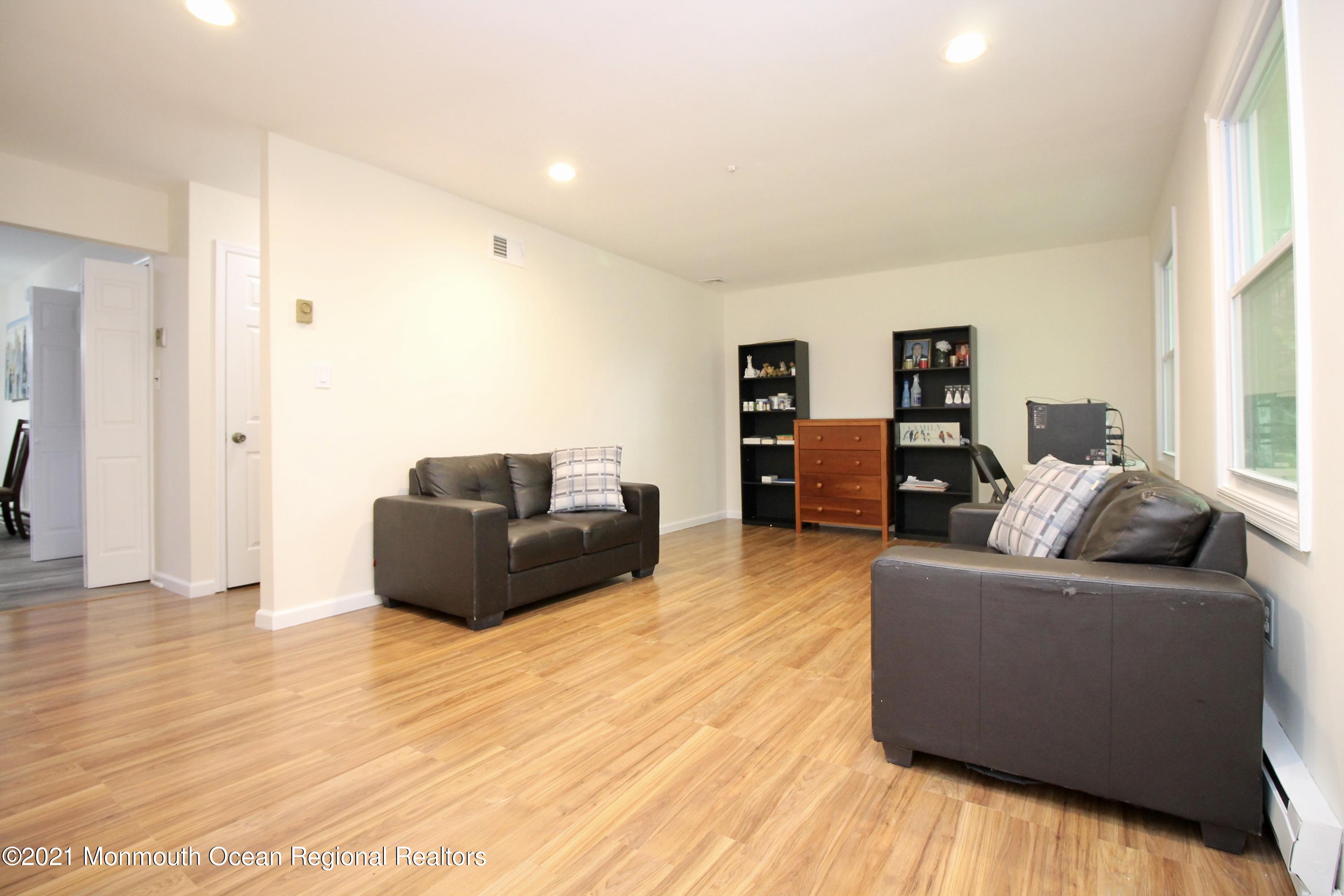 152 Cours De Pasteur, Unit E Freehold, NJ 07728 - Photo 3 of 21 a living room with furniture and a flat screen tv