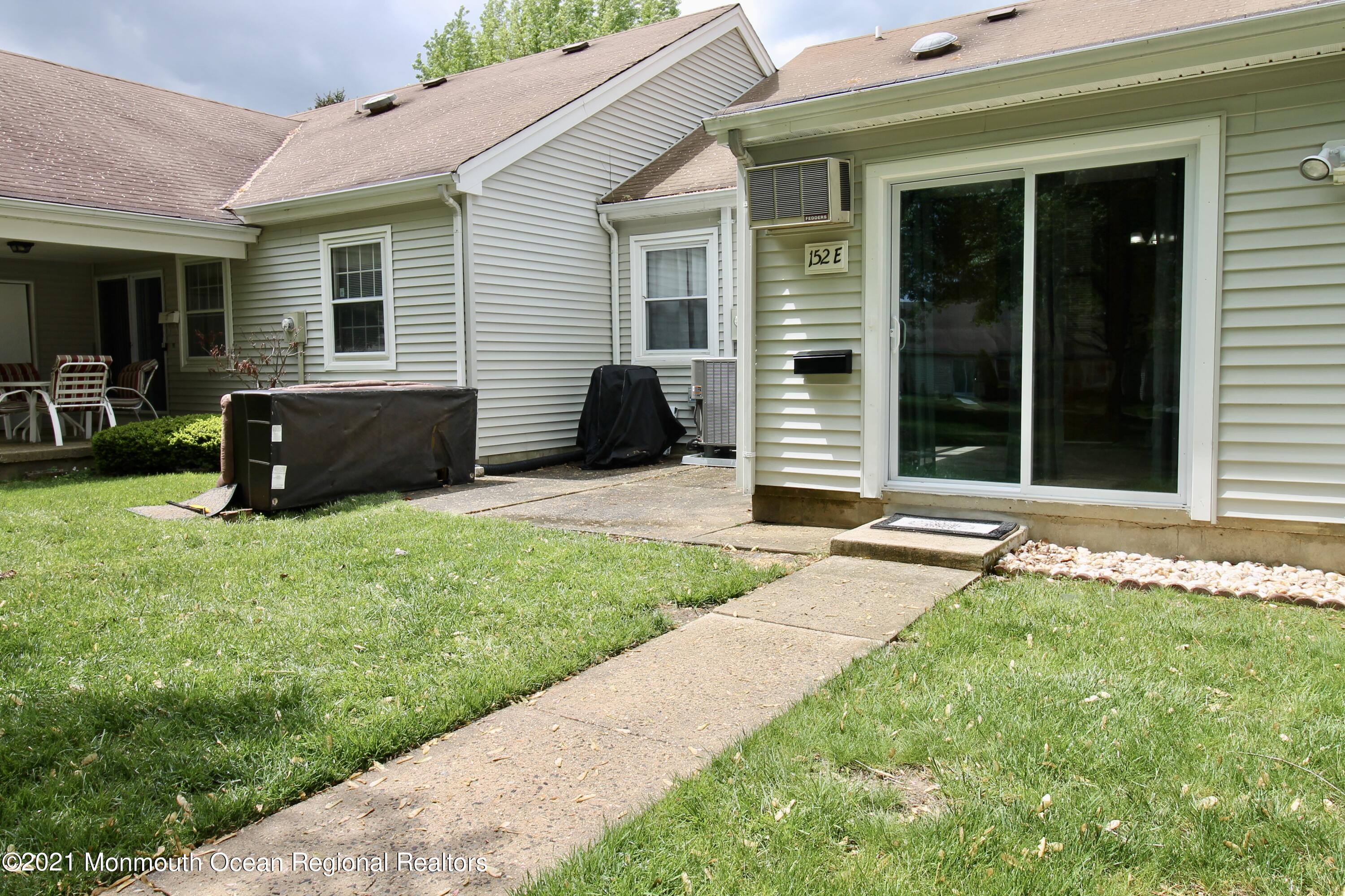 152 Cours De Pasteur, Unit E Freehold, NJ 07728 - Photo 21 of 21 a front view of a house with a yard and fence
