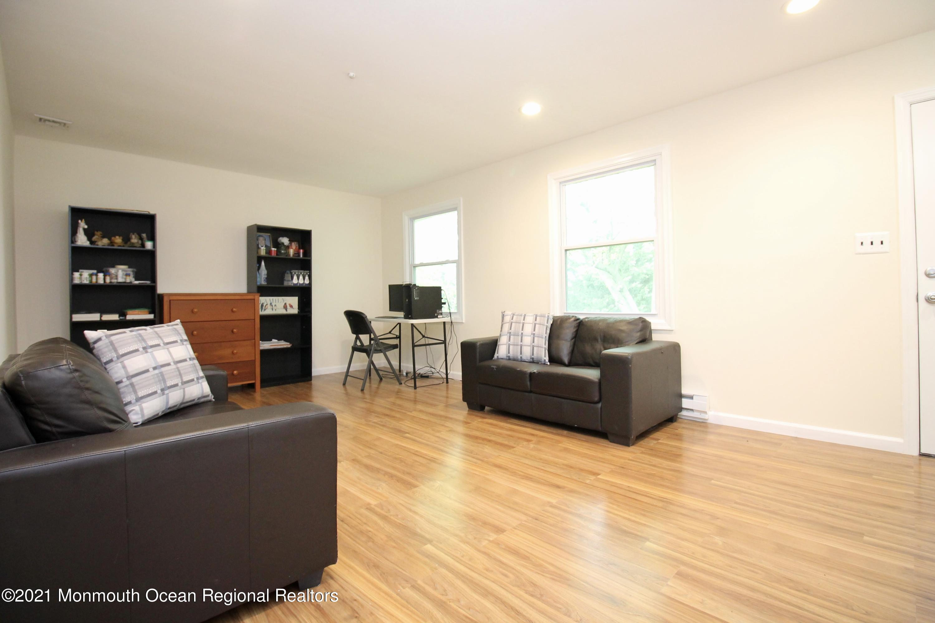 152 Cours De Pasteur, Unit E Freehold, NJ 07728 - Photo 4 of 21 a living room with furniture and a wooden floor