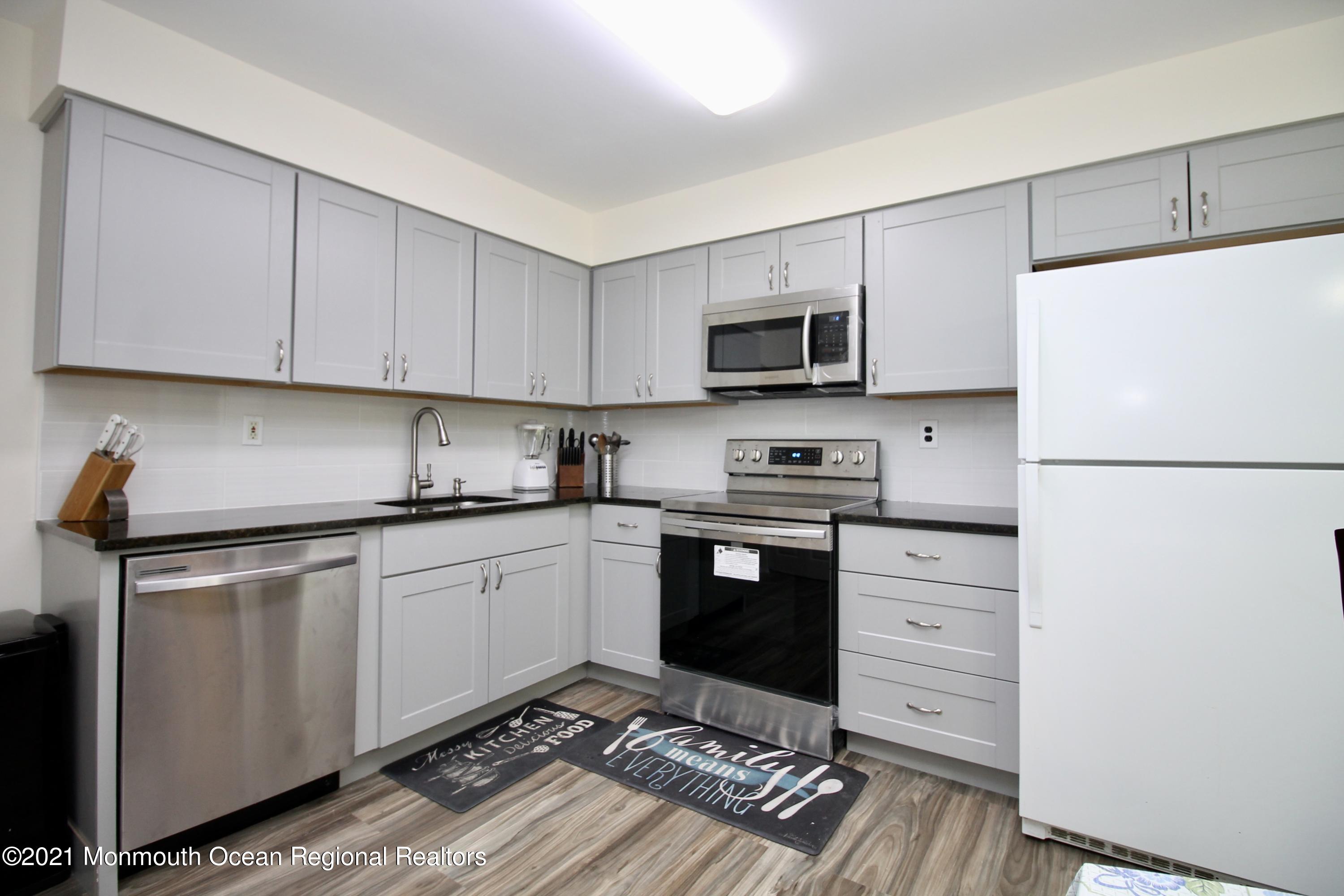 152 Cours De Pasteur, Unit E Freehold, NJ 07728 - Photo 6 of 21 a kitchen with granite countertop a refrigerator stove and microwave