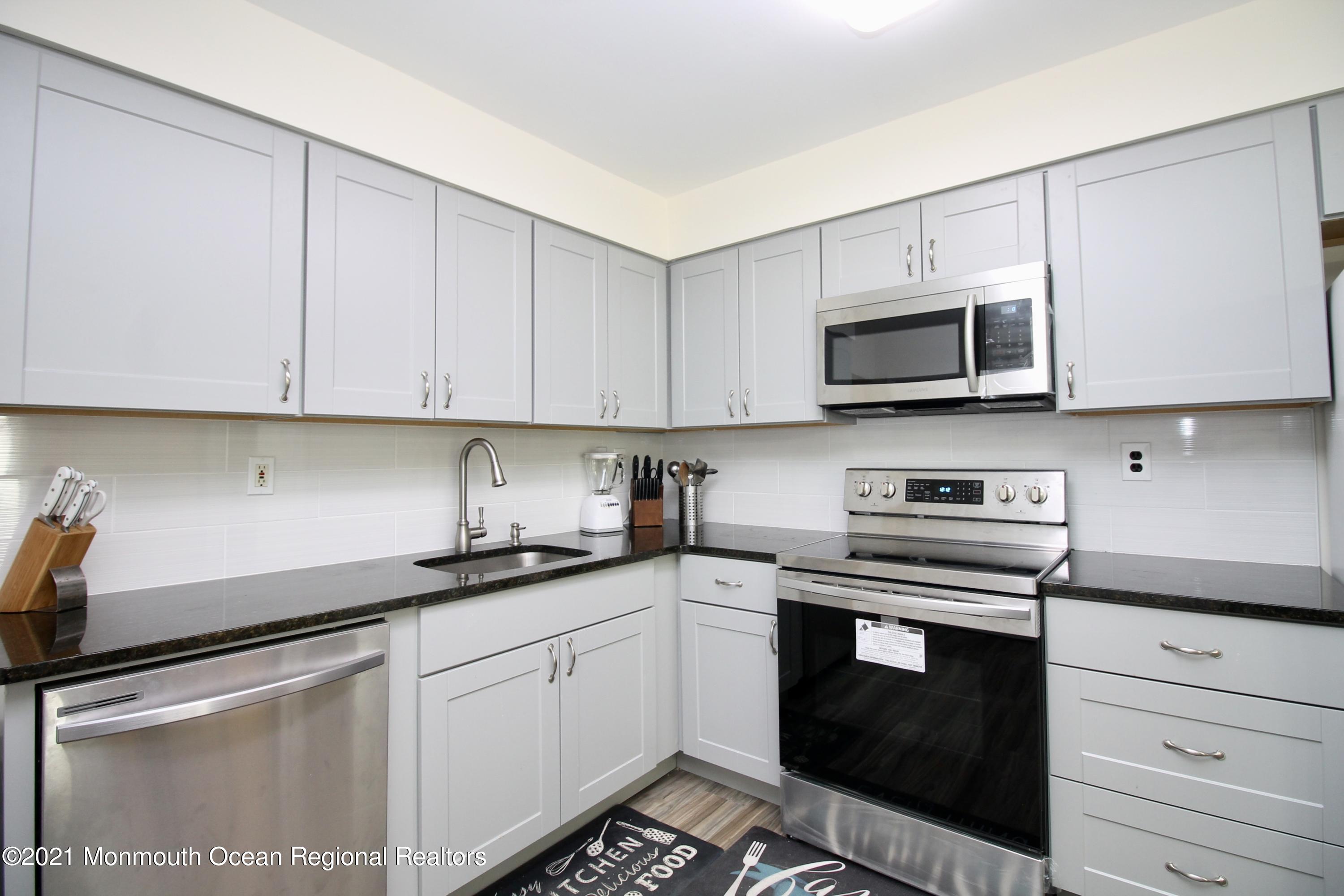 152 Cours De Pasteur, Unit E Freehold, NJ 07728 - Photo 7 of 21 a kitchen with cabinets stainless steel appliances and a sink