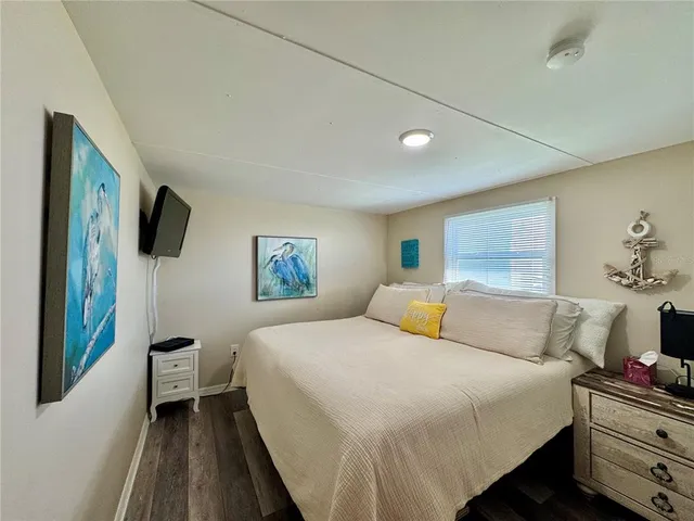 a bedroom with a large bed and a tv on the dresser