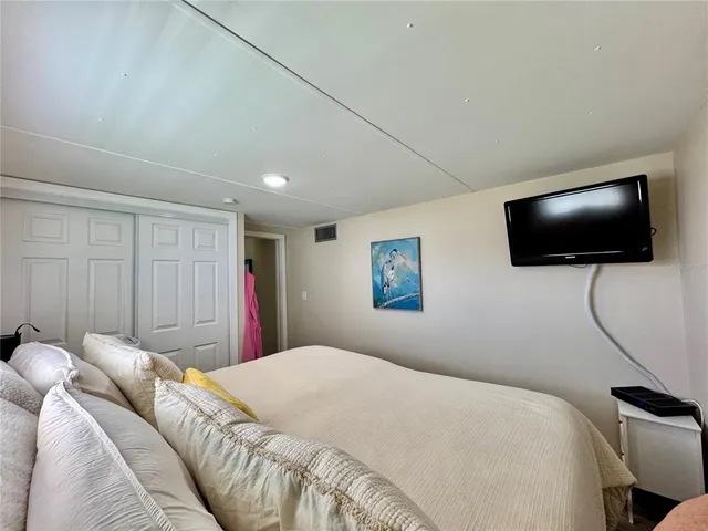 a bedroom with a bed and a flat screen tv