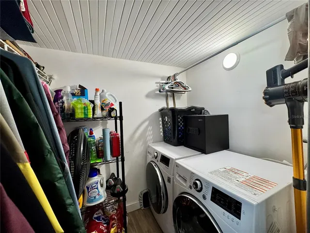a utility room with dryer washer and stair