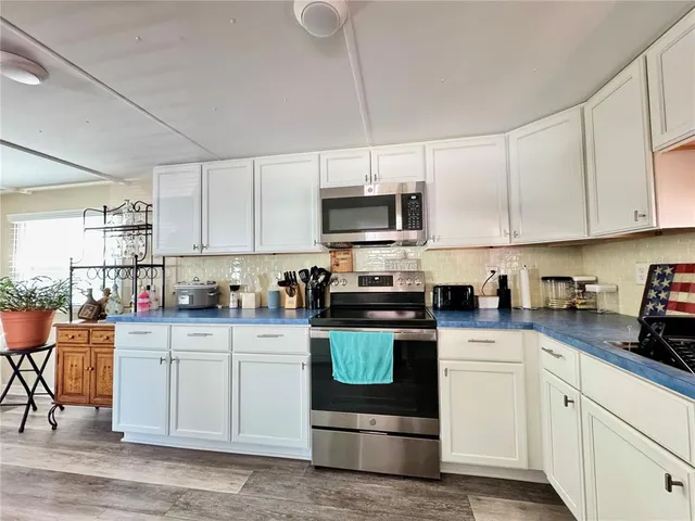 a kitchen with stainless steel appliances granite countertop a stove and white cabinets