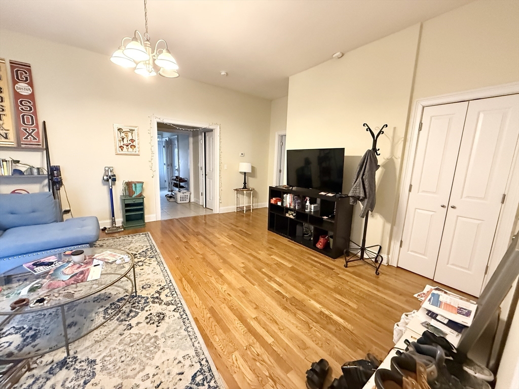 36 Hawthorne Street, Unit 1 Boston, MA 02119 - Photo 10 of 12 a bed room with a bed mirror and a flat tv screen