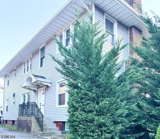 a front view of a house with a tree