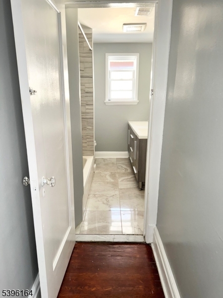 42 Clinton Place, Unit 2 Newark, NJ 07108 - Photo 12 of 20 a view of a hallway with wooden floor and a bathroom