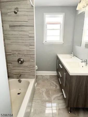 a bathroom with a tub a sink a mirror and a shower