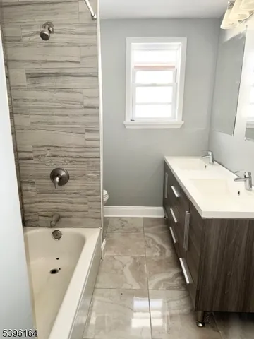 a bathroom with a tub a sink a mirror and a shower