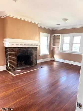 an empty room with wooden floor and fireplace
