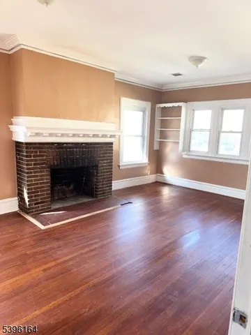 an empty room with wooden floor and fireplace