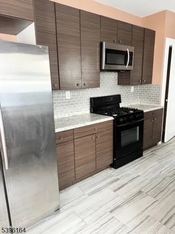 a kitchen with stainless steel appliances granite countertop a stove and a microwave