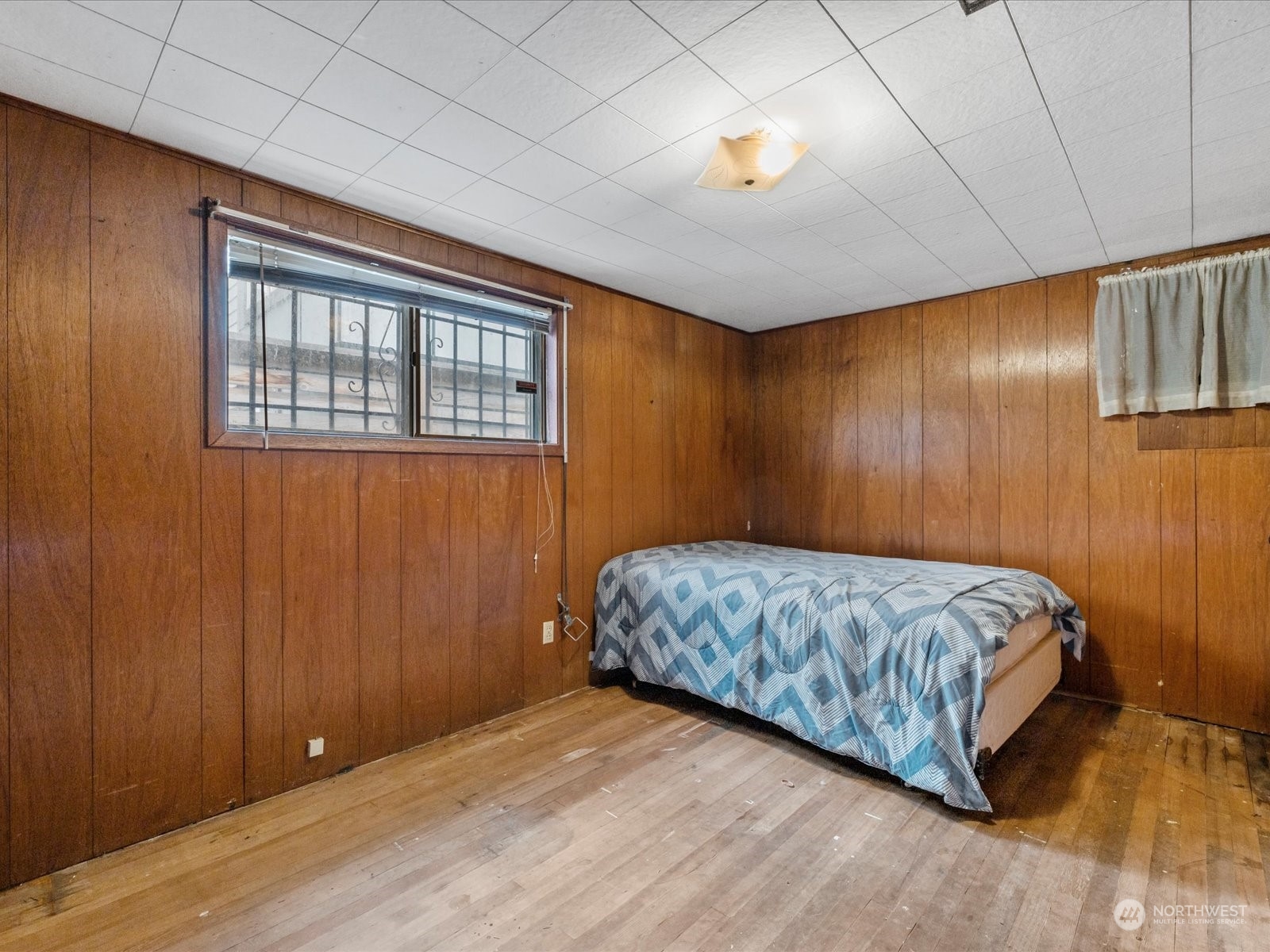 8832 Interlake Avenue North Seattle, WA 98103 - Photo 13 of 29 a bedroom with a bed and lamp with wooden floor