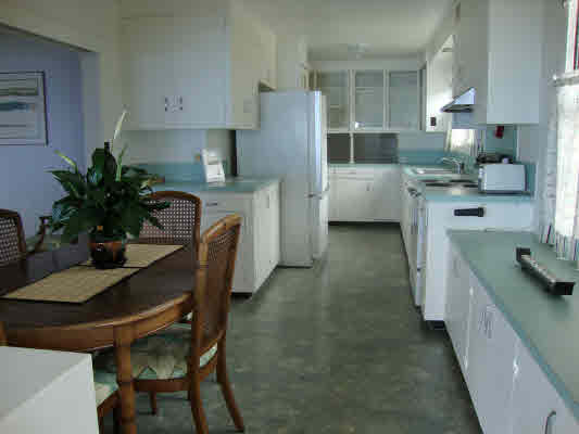81-1018 Captain Cook Road Captain Cook, HI 96704 - Photo 13 of 24 a kitchen with a table chairs refrigerator and cabinets