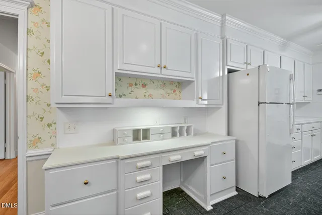 a kitchen with white cabinets and sink