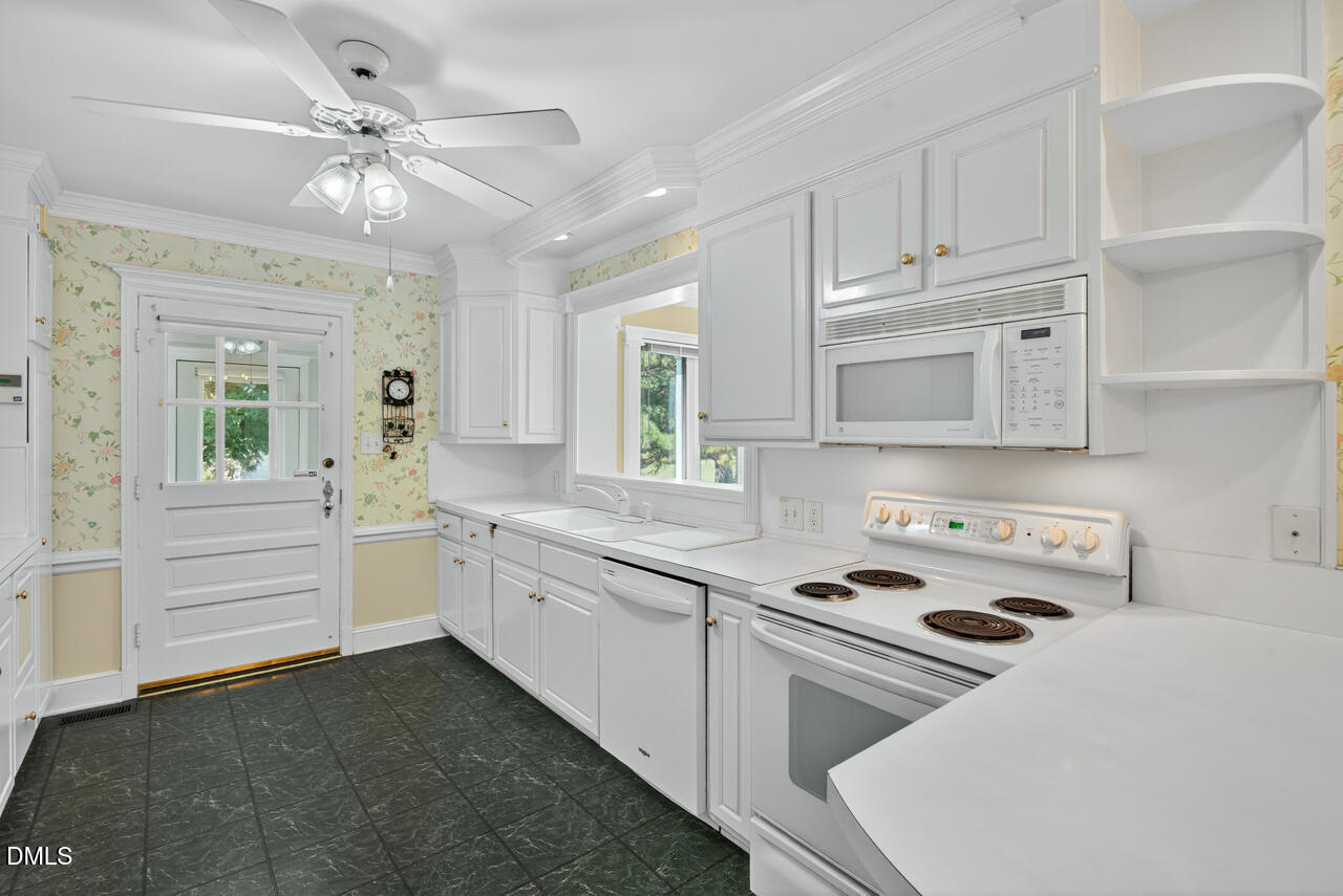 720 Roxboro Road Haw River, NC 27258 - Photo 15 of 55 a kitchen with kitchen island white cabinets and white appliances