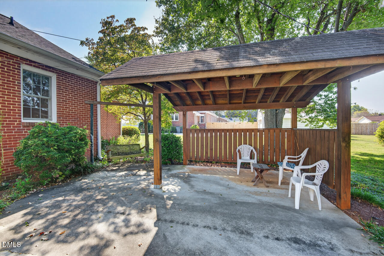 720 Roxboro Road Haw River, NC 27258 - Photo 38 of 55 a view of a patio with table and chairs under an umbrella with a large tree