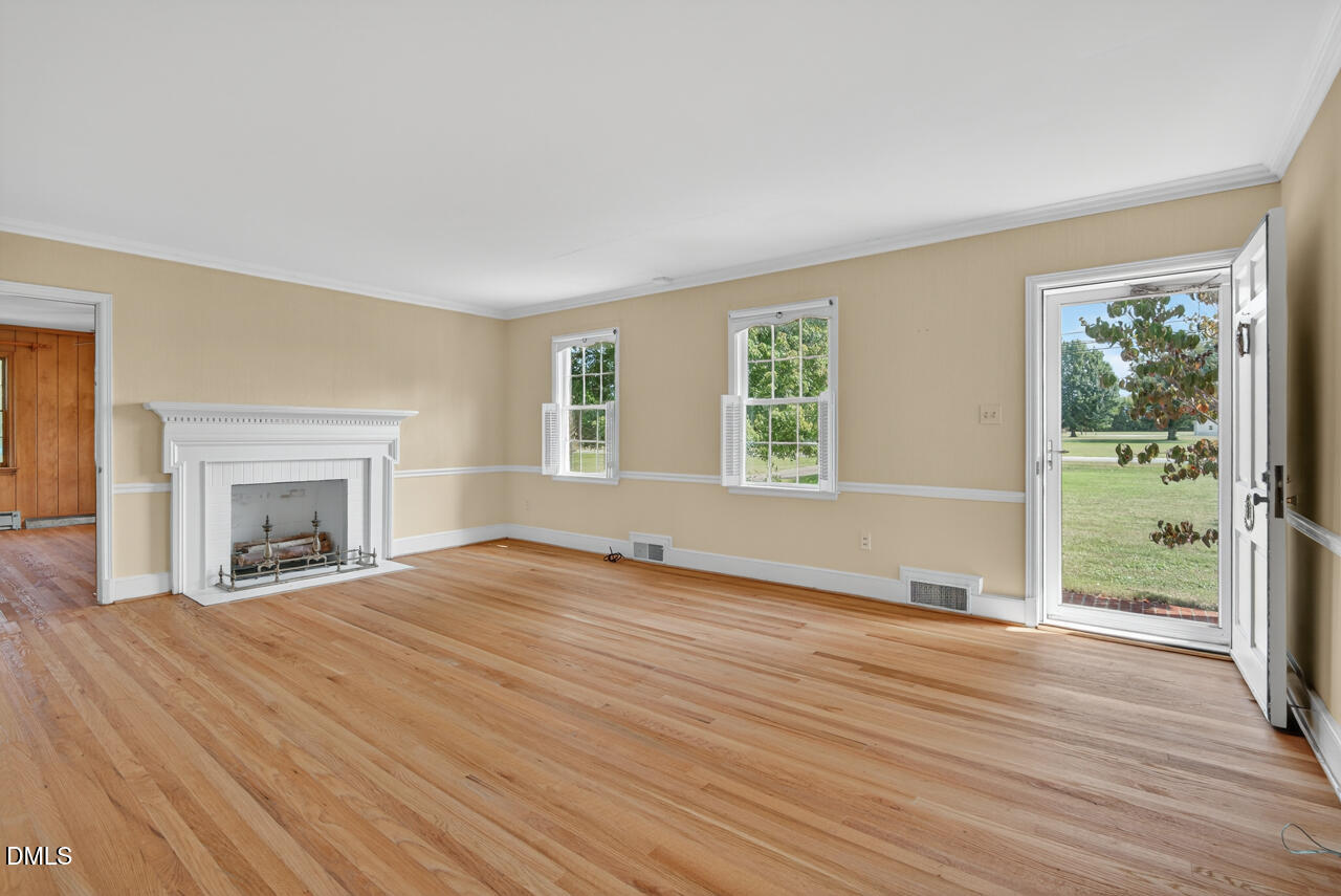 720 Roxboro Road Haw River, NC 27258 - Photo 4 of 55 a view of empty room with wooden floor and fireplace