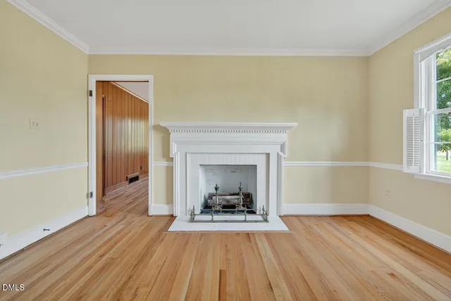 a view of empty room with wooden floor and fireplace