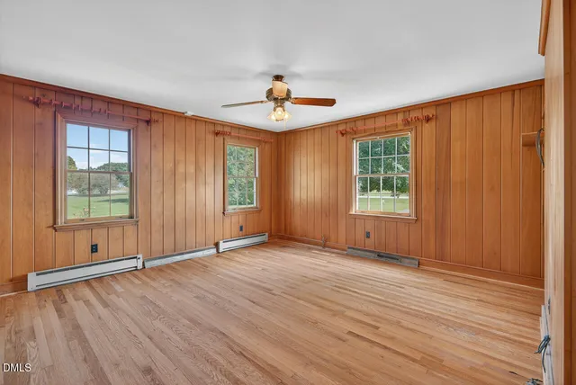 a view of a livingroom with wooden floor and a fireplace