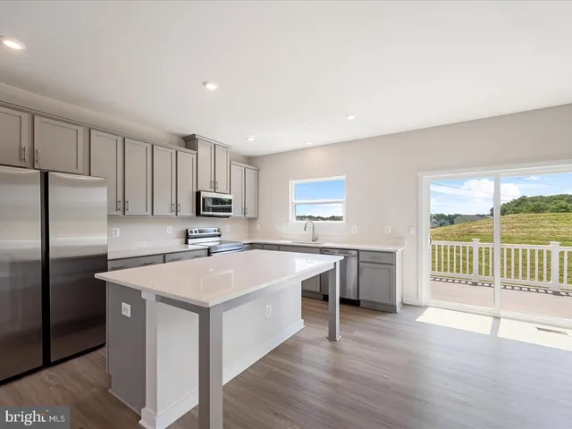 a kitchen with a refrigerator a sink and dishwasher with wooden floor