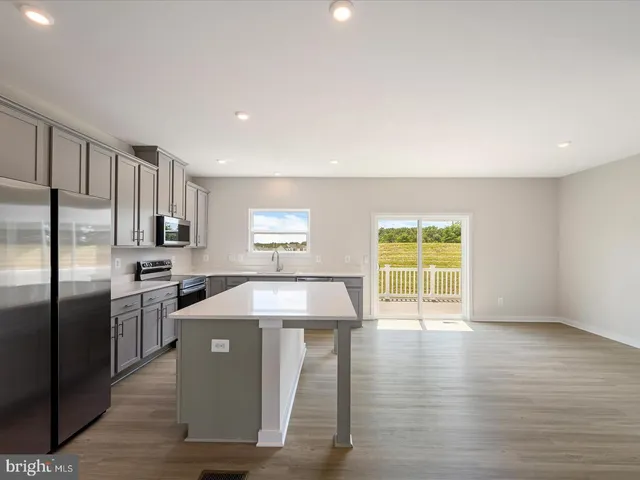 a kitchen with stainless steel appliances granite countertop a refrigerator a sink a stove and oven