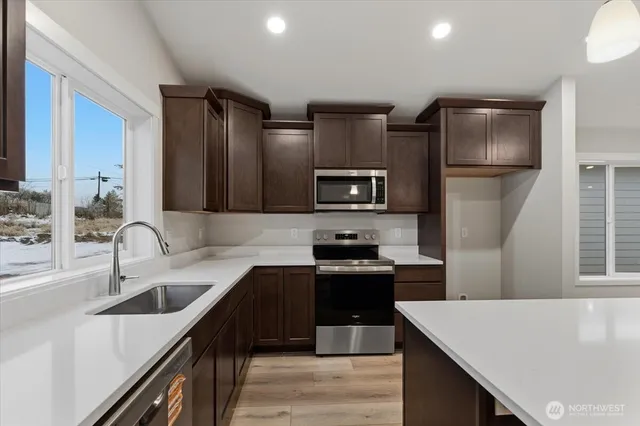 a large kitchen with kitchen island a stove a sink a refrigerator and island