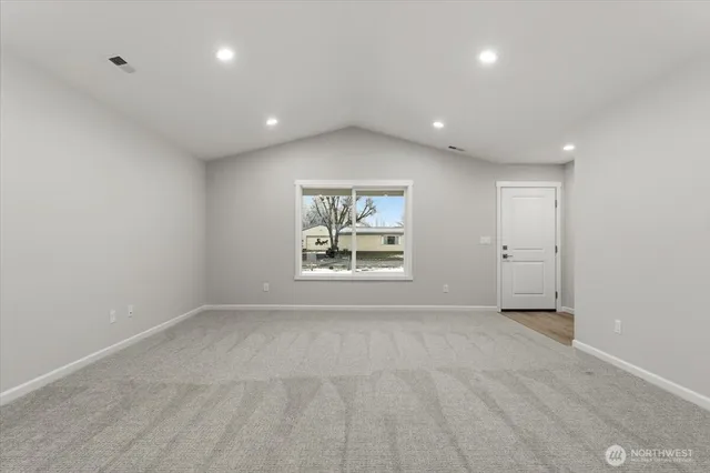 a view of kitchen with granite countertop stainless steel appliances refrigerator sink and cabinets