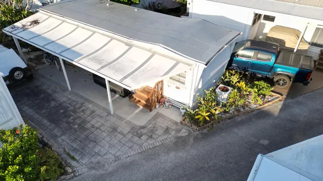 a balcony with couple of flower plants and wooden fence