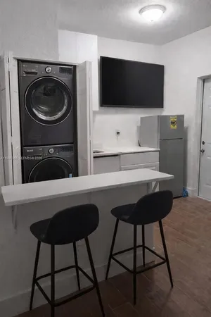 a kitchen with a table chairs and a flat screen tv