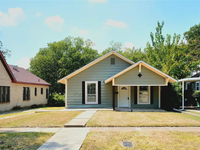 a view of a yard in front of a house with large trees