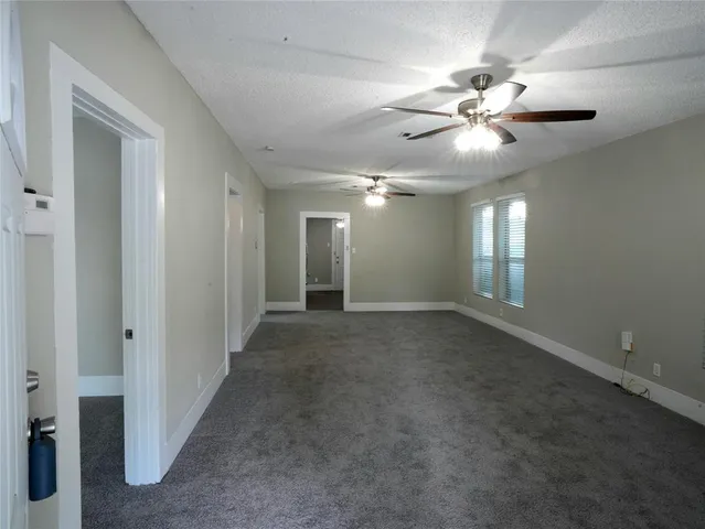 a view of an empty room with a chandelier fan