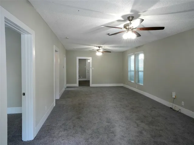 a view of an empty room with a chandelier fan