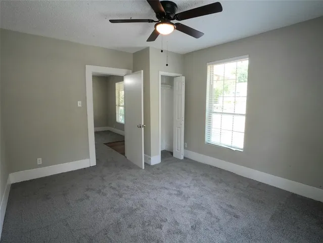 an empty room with fan and windows