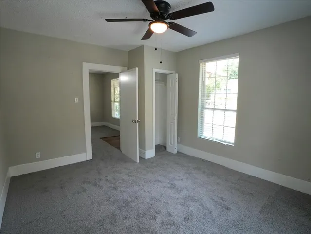 an empty room with fan and windows