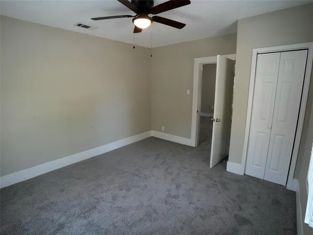 an empty room with a ceiling fan and a window