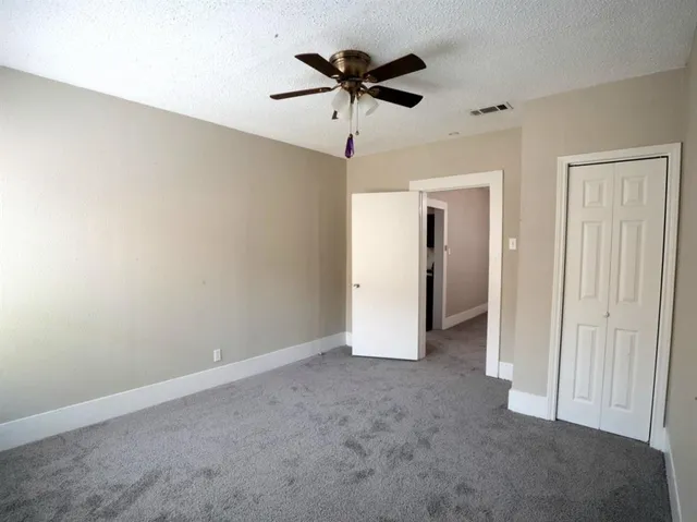 a view of an empty room with a ceiling fan