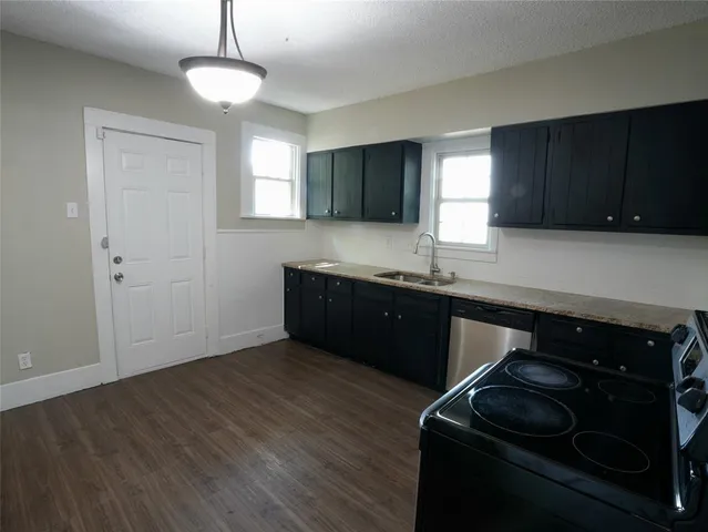 a kitchen with granite countertop wooden cabinets and a stove