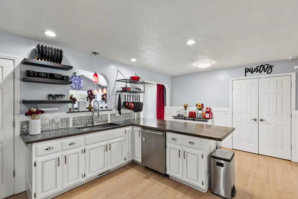a kitchen with white cabinets and sink